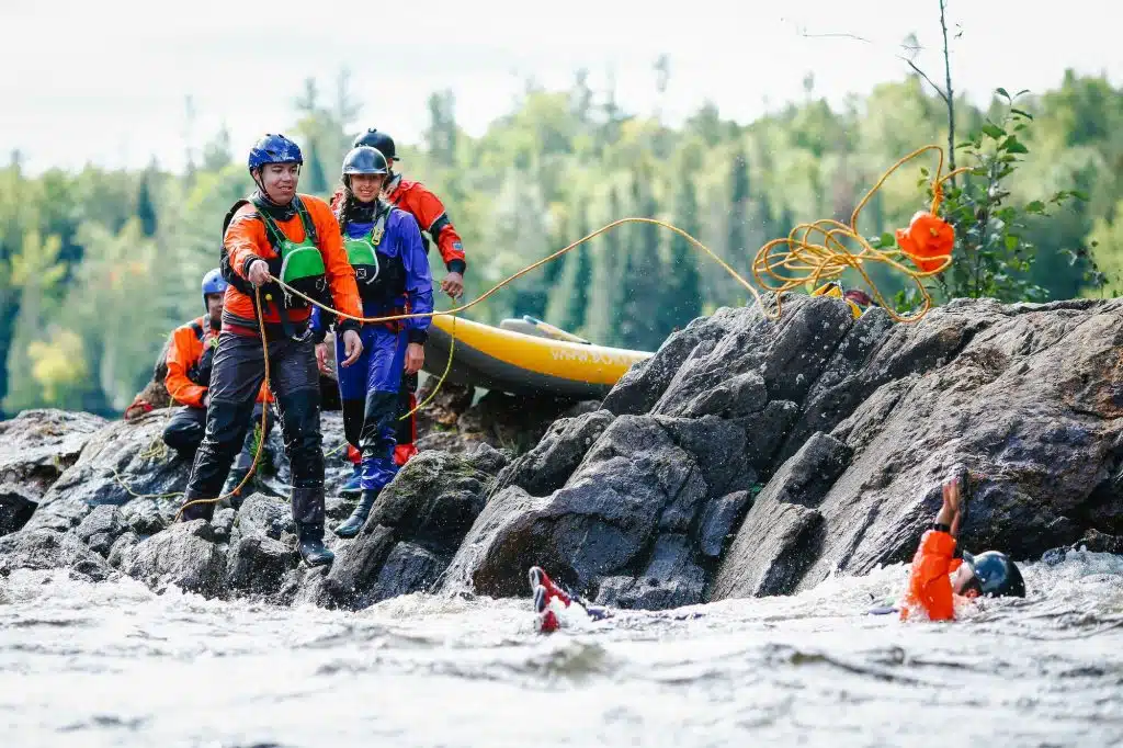 Whitewater rescue paddler using throw bag