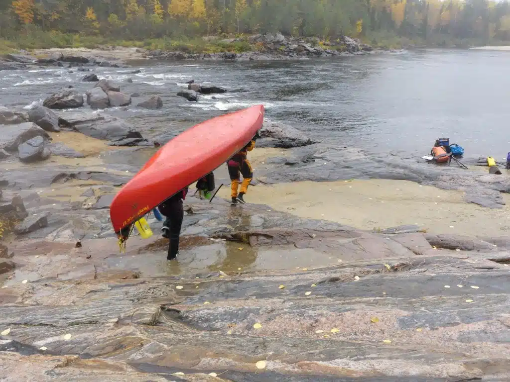 Two people portaging a canoe on the Coulonge River