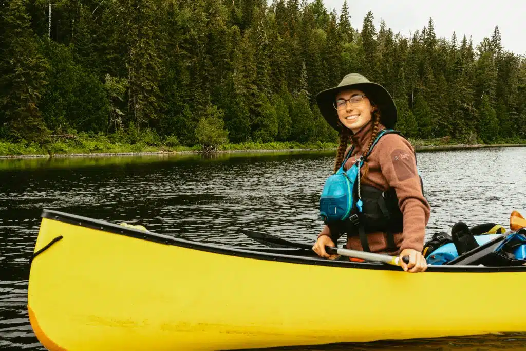 canoe camping in front of pine trees