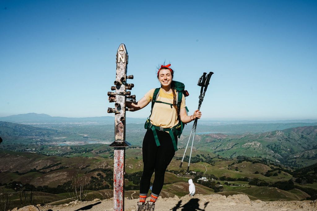Woman posing at the top of Mission Peak along the Ohlone Wilderness Trail
